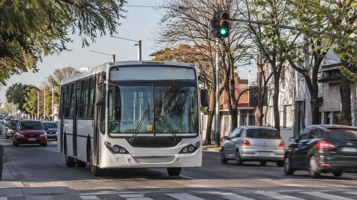 Colectivo genérico circulando por una avenida de barrio en hora pico.