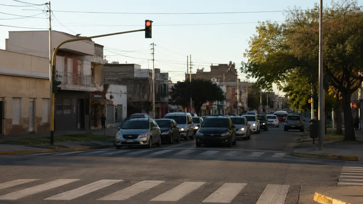 Cruce de calles con semáforo en rojo y tránsito detenido. (ilustración generada con IA)